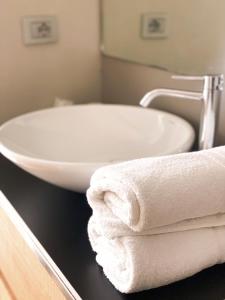 特伦托拉维豪华旅馆的浴室设有白色水槽和台面毛巾