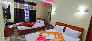 甘托克Hotel Nindik的酒店客房带两张床,房间带两张双人床。