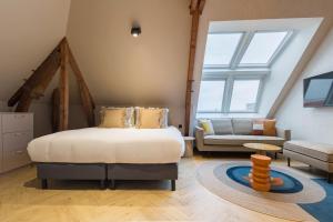 斯海弗宁恩Ocean House Scheveningen的一间卧室配有一张床,客厅配有沙发