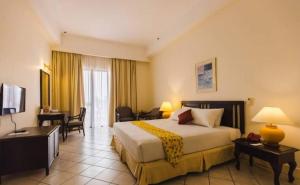 卢穆特卢穆特东方之星度假村的酒店客房设有一张大床和一张书桌。