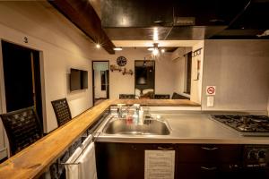 小樽IPPO生活小屋公寓式酒店的厨房配有水槽和炉灶