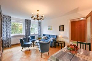 施万高Ferienwohnung Landhaus Helga unterm Schloss的客厅配有蓝色的椅子和桌子