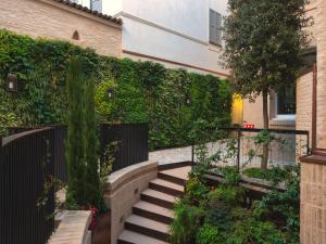 帕尔马Bellacorte Gentiluogo per Viaggiatori的一个带楼梯和绿色树 ⁇ 的花园