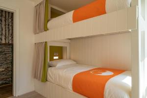 温德米尔Lakes Boutique Hostel Apartment Windermere的一间卧室配有带橙色毯子的双层床
