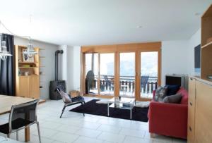 BrienzJust 10min from Lenzerheide - Apartment in Vazerol的客厅配有红色的沙发和椅子