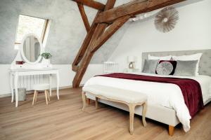 艾森维勒巴赫诺夫DOMAINE DES LUMIERES的白色卧室设有一张大床和镜子