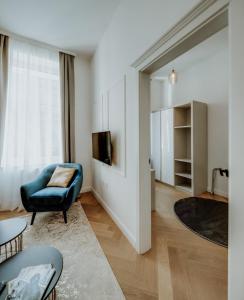 奥西耶克LAVilla Osijek的客厅配有蓝椅和电视