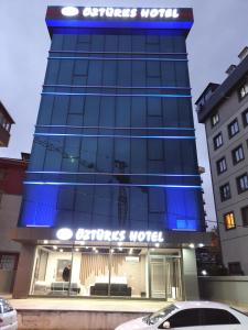 伊斯坦布尔ÖZTÜRKS HOTEL的建筑物一侧有蓝色标志的商店