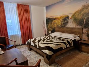蒂米苏尔德约斯Motel “La Butuci”的一间卧室配有斑马印花床和一张桌子