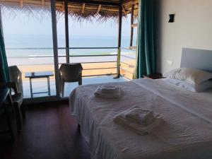 阿贡达Agonda Beach Chalets的一间卧室配有一张床,享有海滩美景