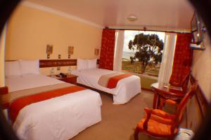 普诺泰彼卡拉拉戈酒店的酒店客房设有两张床和窗户。
