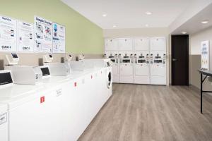 廷利公园WoodSpring Suites Chicago Tinley Park的洗衣房配有白色洗衣机和橱柜