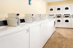 罗密欧维尔WoodSpring Suites Chicago Romeoville的白色洗衣房,配有白色洗衣机和烘干机