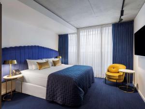 墨尔本The Jazz Corner Hotel Melbourne的酒店客房,配有床和黄色椅子