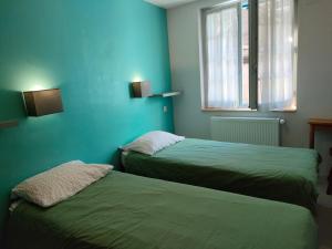 科特雷Gîte Beau Soleil的蓝色墙壁客房的两张床