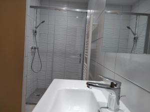 科特雷Gîte Beau Soleil的白色的浴室设有水槽和淋浴。