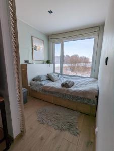 LokutiCozy house with sauna by the lake的一间卧室设有一张床和一个大窗户