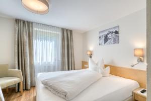 施图本阿尔贝格Landhaus Maria的卧室配有白色床、椅子和窗户
