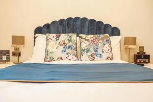 兰卡斯特皇家金斯阿姆酒店的一张带两个枕头的床和一个大床头板