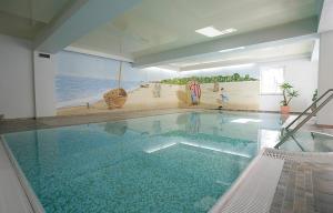 赛巴特班森Ostseeresidenz Gorki- Park - 05 mit Wellness und Schwimmbad的一个带海滩壁画的大型游泳池