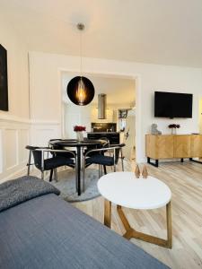 奥尔堡aday - Luxurious Studio Apartment in the Heart of Aalborg的一间带桌子的客厅和一间餐厅