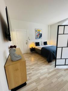 奥尔堡aday - Luxurious Studio Apartment in the Heart of Aalborg的一间卧室,配有一张床和一张桌子上的花瓶