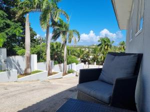 威廉斯塔德Studio Apartment Volterra Curacao的棕榈树门廊上的蓝色沙发