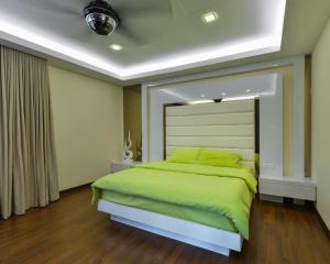 蕉赖Bungalow cheras hijauan residence HomeStay 6 bedrooms的一间位于客房内的带绿床的卧室
