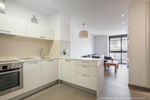 巴塞罗那Flateli Navas D01的白色的厨房配有白色橱柜和客厅。