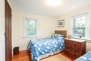法尔茅斯Family Tides的一间卧室配有一张床、一个梳妆台和两个窗户。