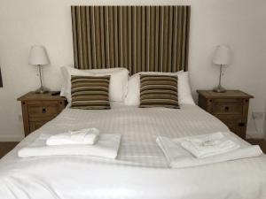 阿尔恩茅斯The Sun Rooms的一张白色的大床,带两条毛巾