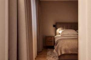 和希格尔TOP Hotel Hochgurgl的卧室配有一张床,床头柜位于床边。