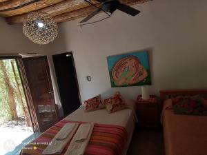 乌尼翁镇Chakana Hospedaje Rural的一间卧室配有一张带两把椅子的床和吊灯。