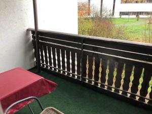莱巴赫Hotel Saarland Lebach的阳台配有红色桌子和长凳