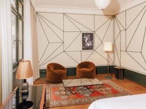 柏林Boutique Hotel Château Royal的卧室配有两把椅子、一张桌子和一张床