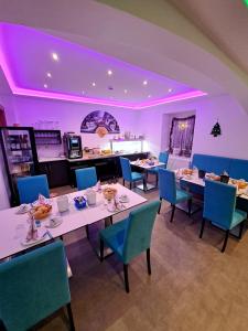 贝希特斯加登阿尔皮纳酒店的一间配备有桌椅和紫色照明的用餐室