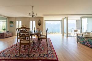 沃韦Lakeside Apartment - Grand appartement familial avec terrasses et vue panoramique的一间位于地毯上的带桌椅的用餐室