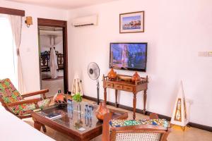 班布里蒙巴萨卡哈马酒店的客厅配有桌子和电视
