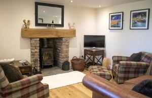 LuibBridge Cottage的客厅设有两张沙发和一个壁炉