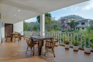 博瓦利Hotel Vista Bhowali, Nainital - Vegetarian的阳台的天井配有桌椅