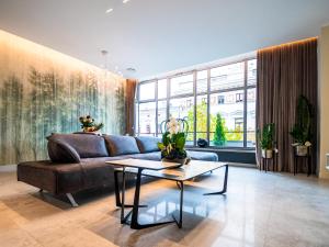 罗兹Pietryna Apartments Luxury - Sauna , Jacuzzi , Bezpośrednio przy ul Piotrkowskiej的客厅配有沙发和桌子