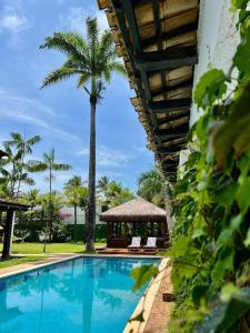 瓜鲁雅Pousada Casa Paradiso Guarujá的一个带凉亭和棕榈树的游泳池