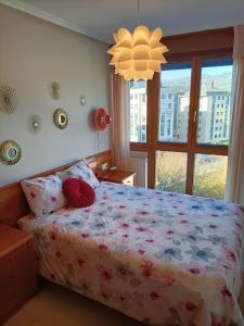 奥维多LA ERIA I, muy soleado, Wifi, garaje, 15 min a pie al centro的一间卧室配有一张带花卉床罩的床和窗户。