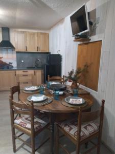 沃雅尼Le Perce Neige的厨房配有木桌、椅子和电视