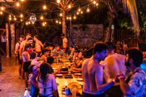 奥尔沃克斯岛Che Holbox Hostel & Bar Adults Only的一群坐在聚会桌旁的人