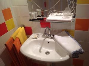 莱顿法米莉奎尔霍斯特酒店的浴室内有色彩缤纷的瓷砖,配有白色水槽