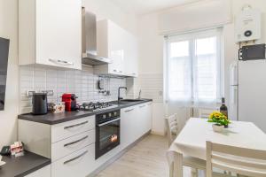 米兰Casaballi Milano MM3 Trilocale的厨房配有白色家电和餐桌,设有用餐室