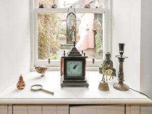 库珀Wonderland Cottage的坐在窗前的台面上的钟