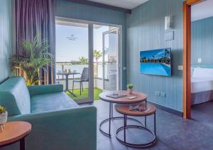 英格兰海滩Axel Beach Maspalomas - Adults Only的酒店客房设有沙发、桌子和床。
