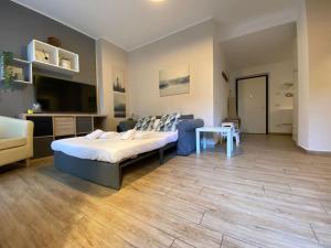 圣多纳托-米拉内塞NEW - Nuovo appartamento in centro的一间带大床的卧室和一间客厅